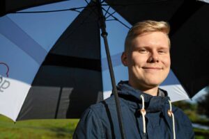 Aleksi Lohtander hymyilee sateenvarjon alla